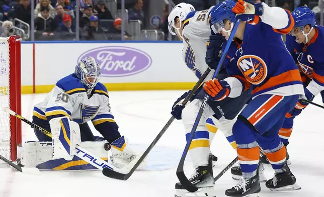 St. Louis Blues goaltender Jordan Binnington (50) makes a save against the New York Islanders during the second period of an NHL hockey game, Saturday, Nov. 23, 2024, in New York. (AP Photo/Noah K. Murray)