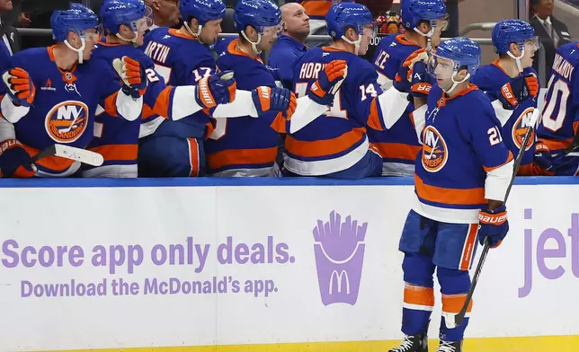 New York Islanders center Kyle Palmieri (21) celebrates with teammates after scoring a goal against the St. Louis Blues head coach Steve Ott () during the first period of an NHL hockey game, Saturday, Nov. 23, 2024, in New York. (AP Photo/Noah K. Murray)