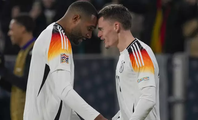 Germany's Florian Wirtz celebrates with Jonathan Tah, left, after scoring his side's fourth goal during the Nations League group soccer match between Germany and Bosnia in Freiburg, Germany, Saturday, Nov. 16, 2024. (AP Photo/Michael Probst)