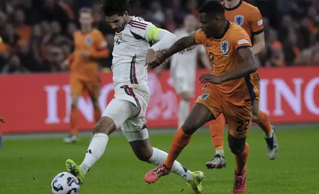 Hungary's Dominik Szoboszlai, left, duels for the ball with Denzel Dumfries of the Netherlands during the UEFA Nations League soccer match between Netherlands and Hungary, at the Johan Cruyff ArenA, in Amsterdam, Netherlands, Saturday, Nov. 16, 2024. (AP Photo/Patrick Post)