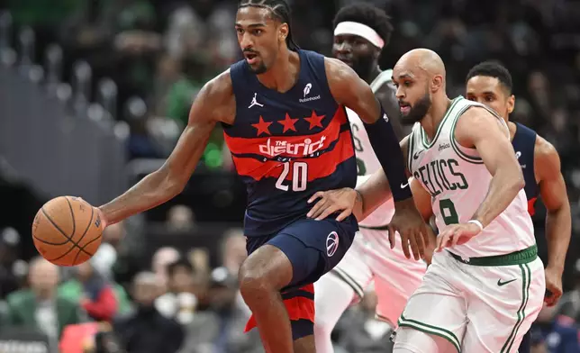 Washington Wizards forward Alexandre Sarr (20) heads down court after gathering a loose ball from Boston Celtics guard Derrick White, right, during the first half of an NBA basketball game Friday, Nov. 22, 2024, in Washington. (AP Photo/John McDonnell)