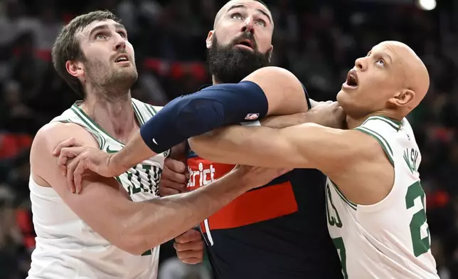 L to R: Boston Celtics center Luke Kornet, Washington Wizards center Jonas Valanciunas, and Celtics guard Jordan Walsh vie for a rebound during the first half of an NBA basketball game Friday, Nov. 22, 2024, in Washington. (AP Photo/John McDonnell)