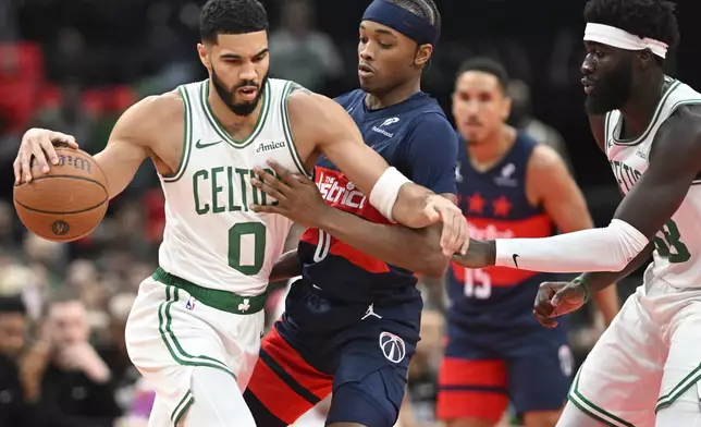 Boston Celtics forward Jayson Tatum (0) collides with Washington Wizards guard Bilal Coulibaly, center during the first half of an NBA basketball game Friday, Nov. 22, 2024, in Washington. (AP Photo/John McDonnell)