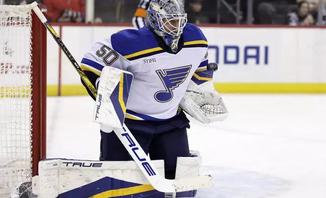 St. Louis Blues goaltender Jordan Binnington makes a save during the second period of an NHL hockey game against the New Jersey Devils Wednesday, Nov. 27, 2024, in Newark, N.J. (AP Photo/Adam Hunger)