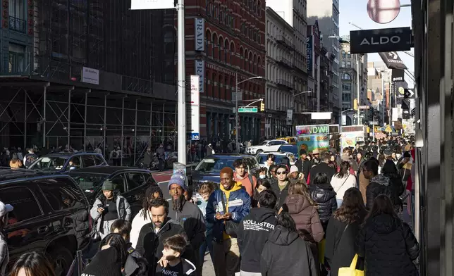 FILE - Shoppers and others walk down a crowded sidewalk on Black Friday in the Soho neighborhood of New York, Nov. 24, 2023. (AP Photo/Peter K. Afriyie, File)