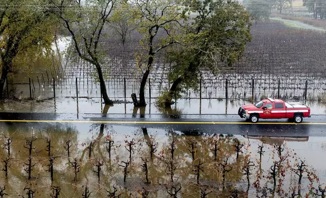 A firefighter drives past flooded vineyards as heavy rains continue in Windsor, Calif., Friday, Nov. 22, 2024. (Photo by Noah Berger)