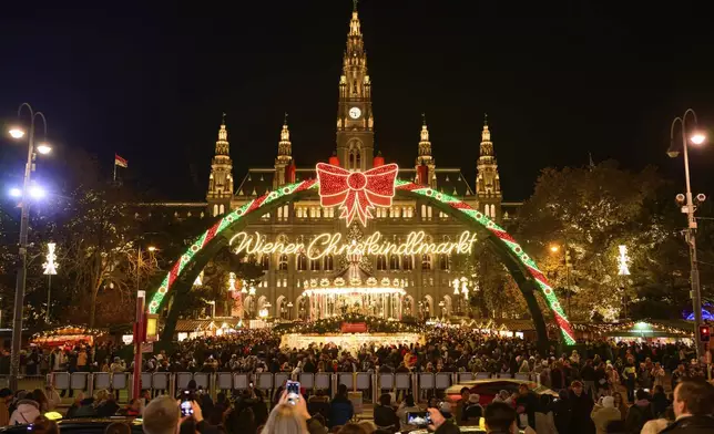 People look at the illuminations at the Wiener Chritkindlmarkt in front of Vienna's city hall, one of Vienna's most popular Christmas markets, in Vienna, Austria, Saturday, Nov. 16, 2024. (AP Photo/Christian Bruna)