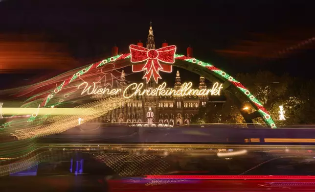 Tramways pass by the illuminated Wiener Chritkindlmarkt in front of Vienna's city hall, one of Vienna's most popular Christmas markets, in Vienna, Austria, Saturday, Nov. 16, 2024. (AP Photo/Christian Bruna)