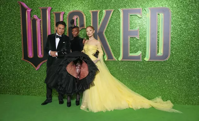 Director Jon M. Chu, from left, Cynthia Erivo and Ariana Grande pose for photographers upon arrival at the premiere of the film 'Wicked' on Monday, Nov. 18, 2024, in London. (Photo by Scott A Garfitt/Invision/AP)