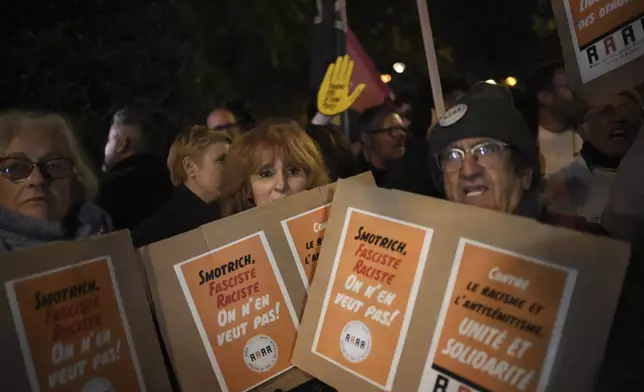 Protesters take part in a rally against the "Israel is Forever" gala organized by far-right Franco-Israeli figures, in Paris, Wednesday, Nov. 13, 2024, on the eve of the UEFA Nations League 2025 soccer match between France and Israel. Placards read " Smotrich, fascist, racist, we don't want him". (AP Photo/Christophe Ena)