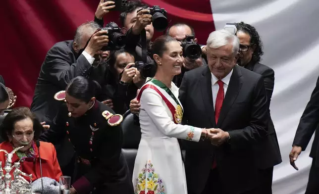 FILE - President Claudia Sheinbaum holds hands with outgoing President Andres Manuel López Obrador after taking the oath of office in the lower chamber of Congress, in Mexico City, Tuesday, Oct. 1, 2024. (AP Photo/Eduardo Verdugo, file)