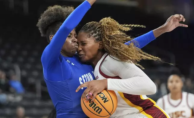 Southern California forward Kiki Iriafen, right, collides with Seton Hall forward Yaya Lops during the second half of an NCAA women's college basketball game in Palm Desert, Calif., Wednesday, Nov. 27, 2024. (AP Photo/Jae C. Hong)