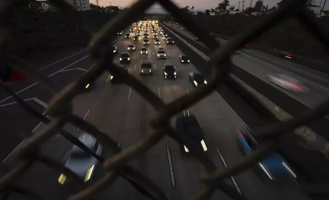 Traffic builds as cars make their way along a highway the day before Thanksgiving, Wednesday, Nov. 27, 2024, in San Diego. (AP Photo/Gregory Bull)