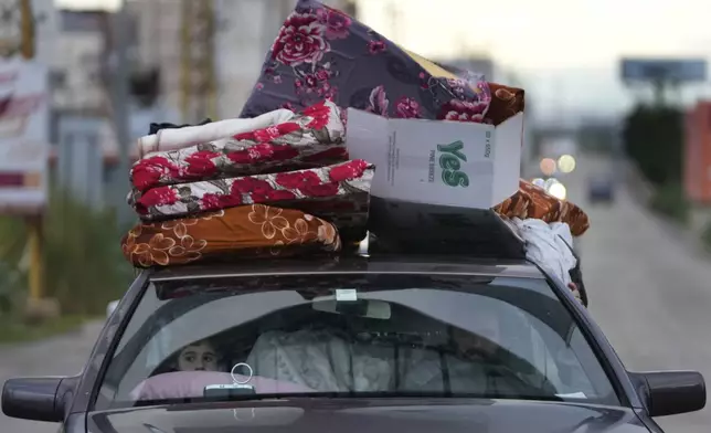 A Lebanese family returns back to their village with their belongings after a ceasefire between Hezbollah and Israel began early morning, in Tyre, south Lebanon, Wednesday, Nov. 27, 2024. (AP Photo/Hussein Malla)