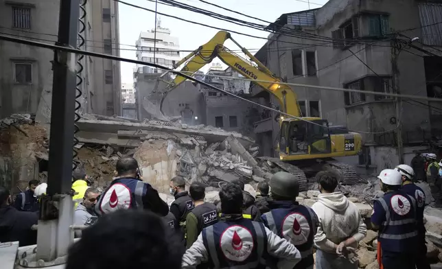 Rescuers use an excavator as they search for victims at the site of an Israeli airstrike that targeted a building in Beirut, Lebanon, Tuesday, Nov. 26, 2024. (AP Photo/Hassan Ammar)