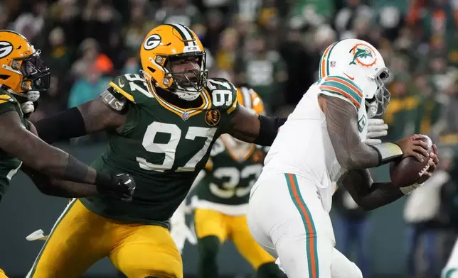 Green Bay Packers defensive tackle Kenny Clark (97) sacks Miami Dolphins quarterback Tua Tagovailoa during the second half of an NFL football game Thursday, Nov. 28, 2024, in Green Bay, Wis. (AP Photo/Morry Gash)