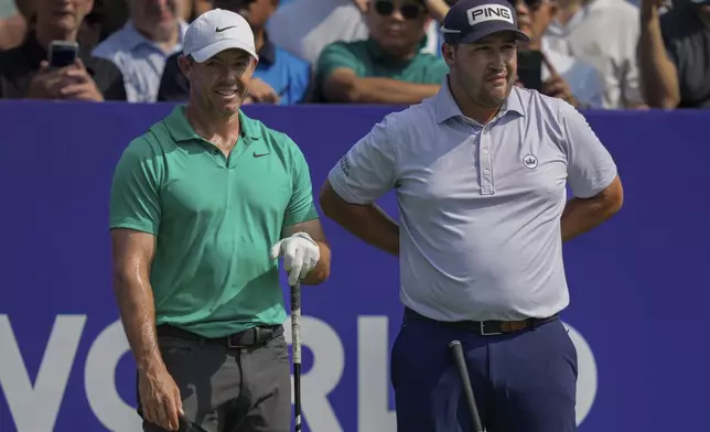 Rory McIlroy of Northern Ireland, left, and Thriston Lawrence of South Africa wait before the first tee off during the first round of World Tour Golf Championship in Dubai, United Arab Emirates, Thursday, Nov. 14, 2024. (AP Photo/Altaf Qadri)