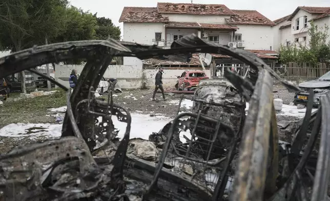 Israeli police bomb squad inspect the site after a missile fired from Lebanon hit the area in Petah Tikva, outskirts of Tel Aviv, Israel, Sunday Nov. 24, 2024. (AP Photo/Oded Balilty)