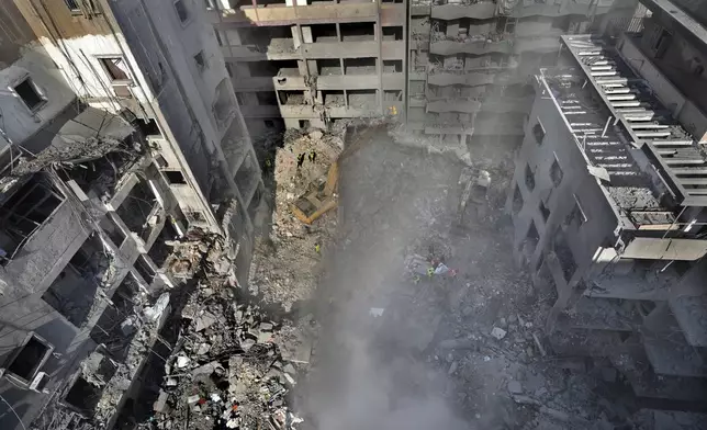 Rescue workers search for victims at the site of an Israeli airstrike that hit central Beirut, Lebanon, Saturday, Nov. 23, 2024. (AP Photo/Hussein Malla)