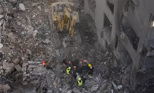 Rescue workers search for victims at the site of an Israeli airstrike that hit central Beirut, Lebanon, Saturday, Nov. 23, 2024. (AP Photo/Hussein Malla)