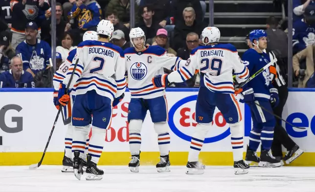 Edmonton Oilers center Connor McDavid (97) celebrates with teammates after scoring against the Toronto Maple Leafs during the second period of an NHL hockey game, Saturday, Nov. 16, 2024 in Toronto. (Christopher Katsarov/The Canadian Press via AP)