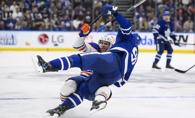 Edmonton Oilers center Connor McDavid (97) and Toronto Maple Leafs center John Tavares (91) collide during the second period of an NHL hockey game, Saturday, Nov. 16, 2024 in Toronto. (Christopher Katsarov/The Canadian Press via AP)