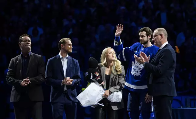 Toronto Maple Leafs defenseman Oliver Ekman-Larsson (95) celebrates with family while being honored in a pregame ceremony for 1000 league games ahead of an NHL hockey game against the Edmonton Oilers in Toronto, Saturday, Nov. 16, 2024. (Christopher Katsarov/The Canadian Press via AP)