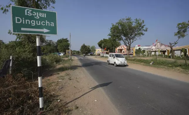 A car moves past a signage of Dingucha village in Gandhinagar, India, Tuesday, Nov. 12, 2024. (AP Photo/Ajit Solanki)