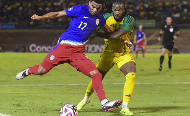 United States' Malik Tillman, left, fights for the ball against Jamaica's Kasey Palmer during a CONCACAF Nations League quarterfinal first leg soccer match in Kingston, Jamaica, Thursday, Nov. 14, 2024. (AP Photo/Collin Reid)