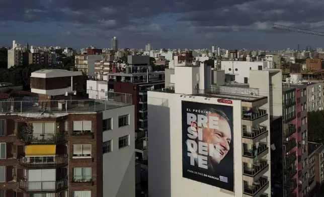 A poster of Alvaro Delgado, presidential candidate for the ruling National Party, covers a building ahead of the presidential run-off election in Montevideo, Uruguay, Friday, Nov. 22, 2024. (AP Photo/Natacha Pisarenko)