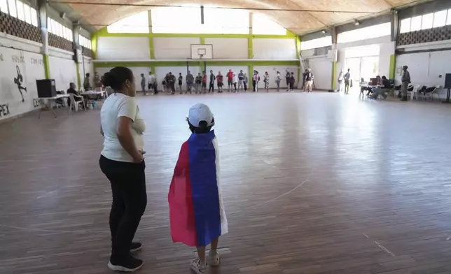 Voters line up at a polling station during the presidential run-off election in Montevideo, Uruguay, Sunday, Nov. 24, 2024. (AP Photo/Matilde Campodonico)