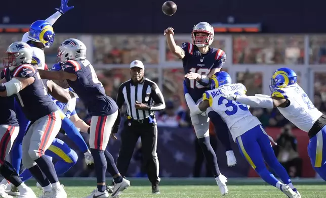 New England Patriots quarterback Drake Maye (10) throws a pass as the Los Angeles Rams defensive line puts on pressure during the first half of an NFL football game, Sunday, Nov. 17, 2024, in Foxborough, Mass. (AP Photo/Steven Senne)