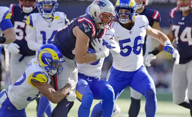 New England Patriots tight end Austin Hooper, center, hangs onto the ball against the Los Angeles Rams during the first half of an NFL football game, Sunday, Nov. 17, 2024, in Foxborough, Mass. (AP Photo/Steven Senne)