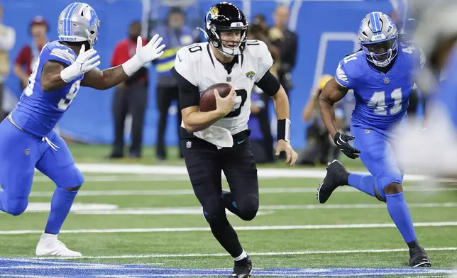 Jacksonville Jaguars quarterback Mac Jones (10) runs the ball against the Detroit Lions during the first half of an NFL football game, Sunday, Nov. 17, 2024, in Detroit. (AP Photo/Duane Burleson)