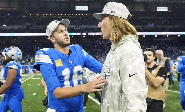 Detroit Lions quarterback Jared Goff (16) talks with Jacksonville Jaguars quarterback Trevor Lawrence after an NFL football game, Sunday, Nov. 17, 2024, in Detroit. (AP Photo/Carlos Osorio)