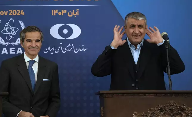 Head of Atomic Energy Organization of Iran Mohammad Eslami, right, tries to listen to a journalist at the conclusion of his joint press conference with International Atomic Energy Agency (IAEA) Director General Rafael Mariano Grossi in Tehran, Iran, Thursday, Nov. 14, 2024. (AP Photo/Vahid Salemi)