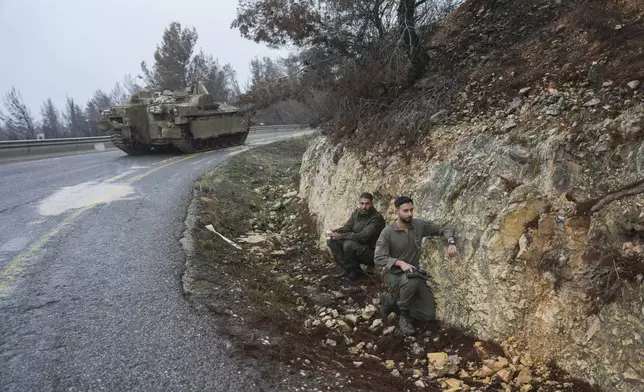 Israeli soldiers take cover on the side of the road during an alert of incoming rockets, near Kiryat Shmona, northern Israel Sunday Nov. 24, 2024. (AP Photo/Ohad Zwigenberg)