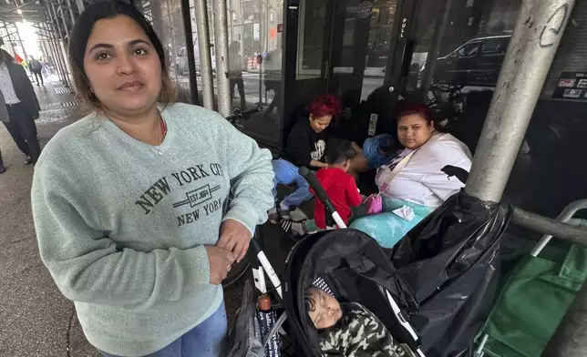 Maribel Hidalgo, 23, of Caracas, Venezuela, stands for a portrait with her son, Daniel, 2, outside a shelter for immigrants in New York, on Wednesday, Nov. 6, 2024. (AP Photo/Cedar Attanasio)