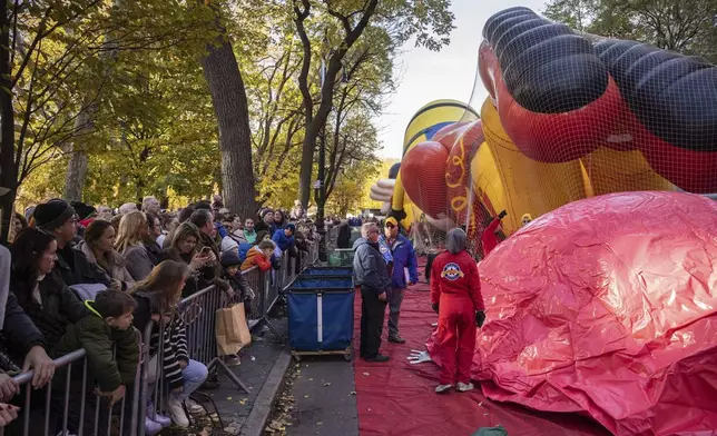 People watch floats being inflated in preparation for the Macy's Thanksgiving Day Parade, Wednesday, Nov. 27, 2024, in New York. (AP Photo/Yuki Iwamura)