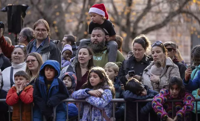 People watch floats being inflated in preparation for the Macy's Thanksgiving Day Parade, Wednesday, Nov. 27, 2024, in New York. (AP Photo/Yuki Iwamura)