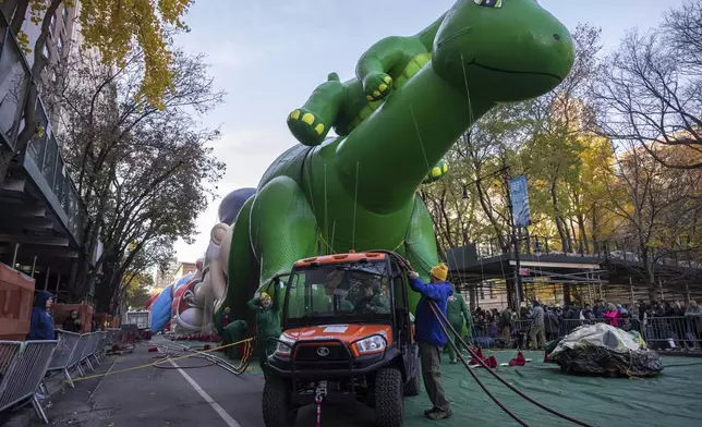 People inflate a float of Sinclair's Dino in preparation for the Macy's Thanksgiving Day Parade, Wednesday, Nov. 27, 2024, in New York. (AP Photo/Yuki Iwamura)