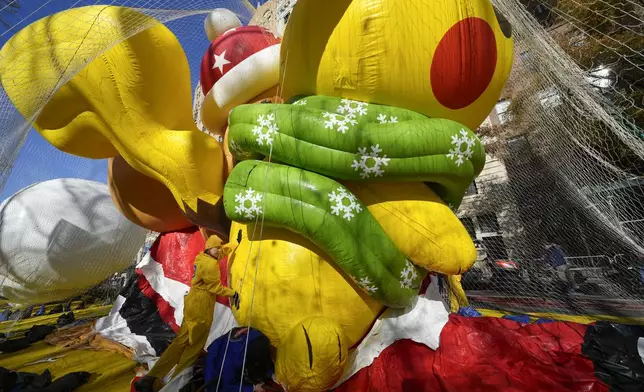 People help to inflate a Pikachu float for the Macy's Thanksgiving Day Parade in New York, Wednesday, Nov. 27, 2024. (AP Photo/Seth Wenig)