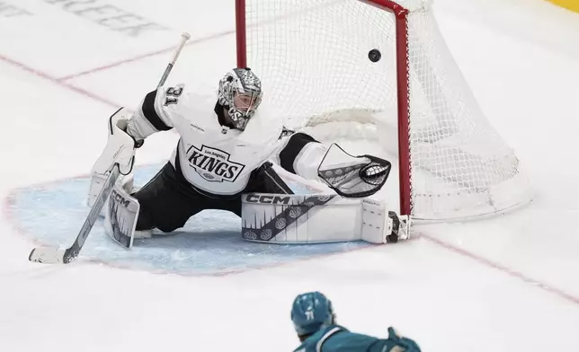 San Jose Sharks center Macklin Celebrini, bottom, scores a goal against Los Angeles Kings goaltender David Rittich during the third period of an NHL hockey game Monday, Nov. 25, 2024, in San Jose, Calif. (AP Photo/Godofredo A. Vásquez)