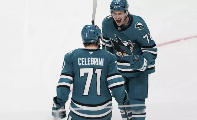 San Jose Sharks center Macklin Celebrini (71) is congratulated by left wing William Eklund after scoring a goal during the third period of an NHL hockey game against the Los Angeles Kings, Monday, Nov. 25, 2024, in San Jose, Calif. (AP Photo/Godofredo A. Vásquez)