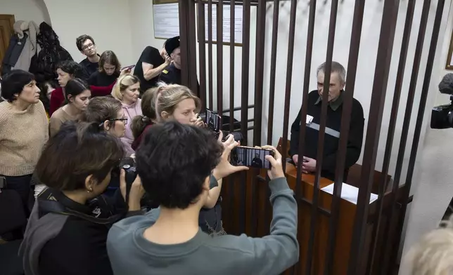 Imprisoned Kremlin critic Alexei Gorinov, sits in a cage of the courtroom as his second trial for criticizing Russia's actions in Ukraine swiftly nears its conclusion in Vladimir, Russia, Friday, Nov. 29, 2024. (AP Photo/Dmitry Serebryakov)