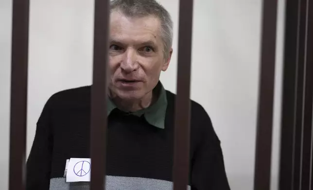 Imprisoned Kremlin critic Alexei Gorinov, sits in a cage at the court as his second trial for criticizing Russia's actions in Ukraine swiftly nears its conclusion in Vladimir, Russia, Friday, Nov. 29, 2024. (AP Photo/Dmitry Serebryakov)