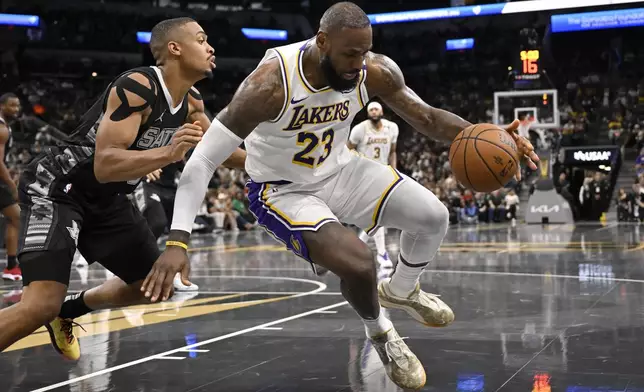 Los Angeles Lakers' LeBron James (23) drives against San Antonio Spurs' Keldon Johnson during the first half of an Emirates NBA Cup basketball game, Friday, Nov. 15, 2024, in San Antonio. (AP Photo/Darren Abate)