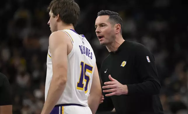 Los Angeles Lakers head coach J.J. Redick, right, speaks with guard Austin Reaves during the first half of their Emirates NBA Cup basketball game against the San Antonio Spurs, Friday, Nov. 15, 2024, in San Antonio. (AP Photo/Darren Abate)