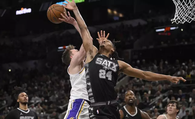 San Antonio Spurs' Devin Vassell (24) blocks a shot attempt by Los Angeles Lakers' Dalton Knecht during the first half of an Emirates NBA Cup basketball game, Friday, Nov. 15, 2024, in San Antonio. (AP Photo/Darren Abate)