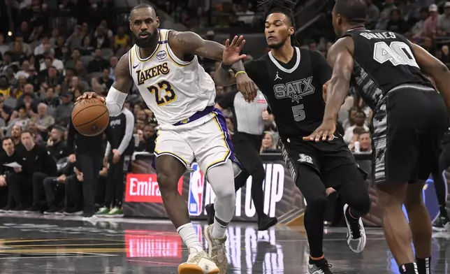 Los Angeles Lakers' LeBron James (23) drives against San Antonio Spurs' Stephon Castle (5) during the first half of an Emirates NBA Cup basketball game, Friday, Nov. 15, 2024, in San Antonio. (AP Photo/Darren Abate)